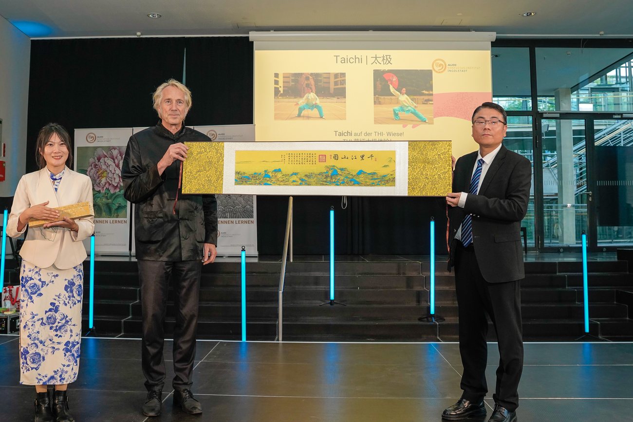 Prof. Dr. Peter Augsdörfer und Ming Deng halten die Bildrolle Qianli jiangshan tu