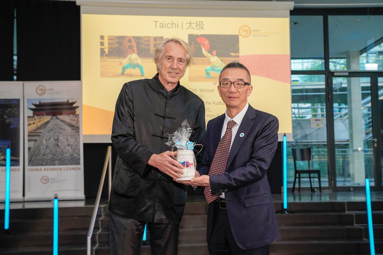 Prof. Dr. Peter Augsdörfer überreicht Prof. Dr. Bo Wu einen bemalten Bierkrug